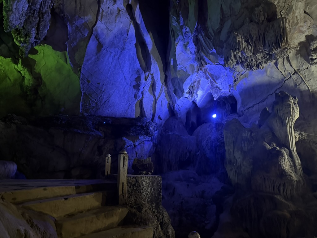 タムジャン洞窟の奥、緑と青の照明と木製遊歩道、鍾乳石が垂れ下がる