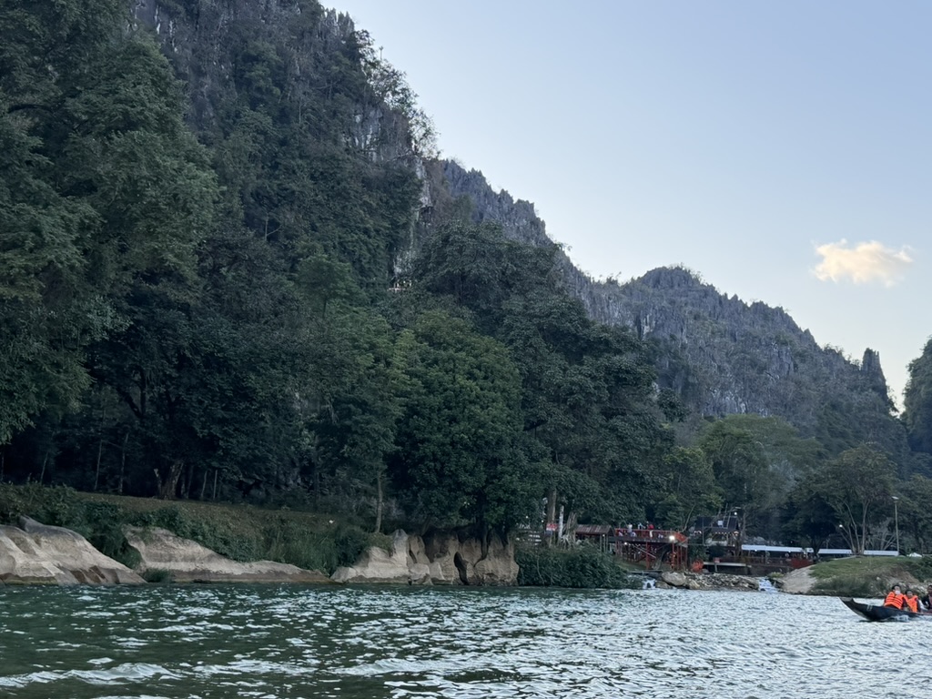 ヴァンヴィエンのカルスト絶壁とナムソン川、ライフジャケットを着た人たちが乗るボート