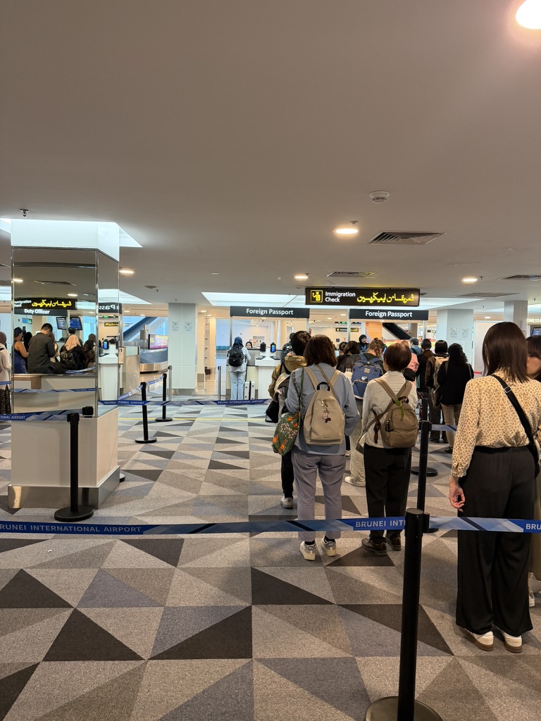 ブルネイ国際空港の入国審査カウンターに並ぶ人々