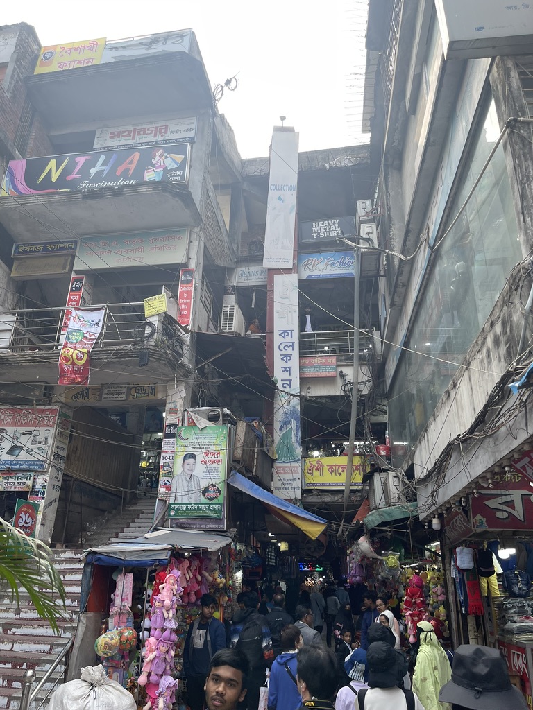 看板と商品が溢れるダッカの市場の路地